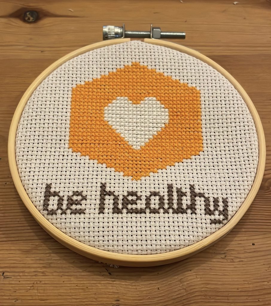 Cross stich of yellow hexagon with be healthy inside