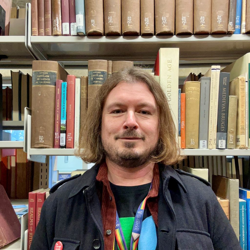 Picture of Sam Gill smiling in the Sydney Jones Library